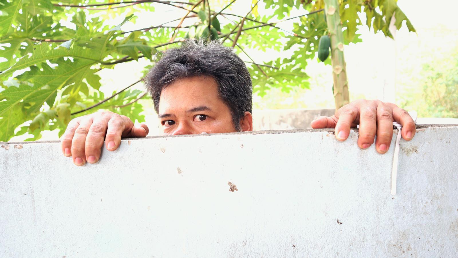 man looking over a fence
