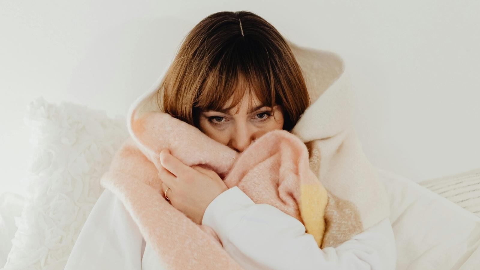 Freezing Night Shift Employee Quits After Boss Accuses Her of Being Impaired for Wearing Blanket cold woman wrapped in a blanket
