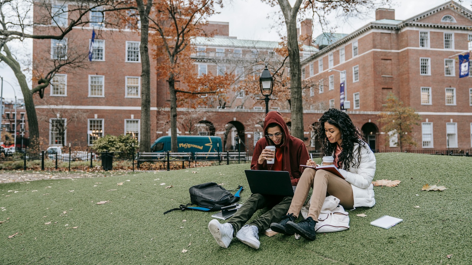 college students sitting out studying on campus