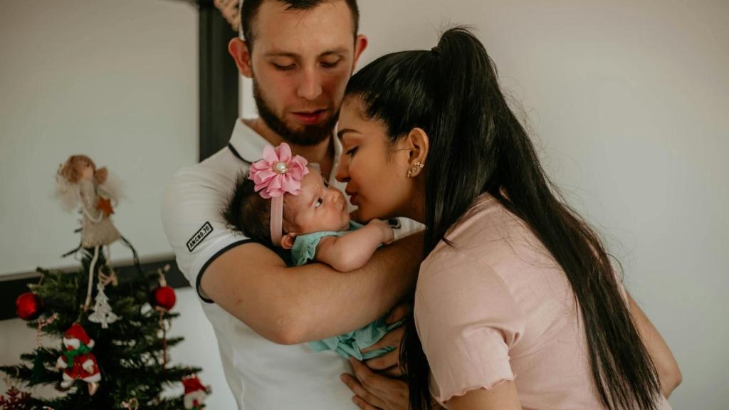 couple with a new baby at christmas time