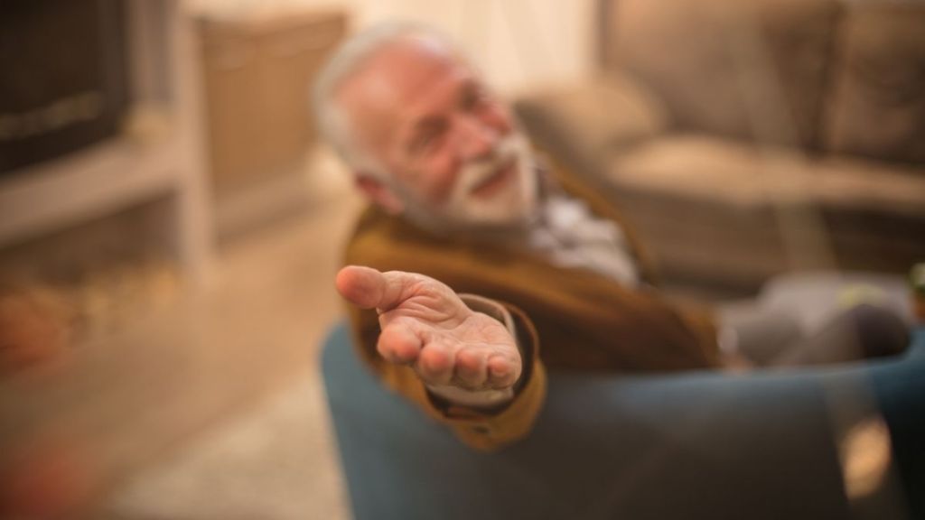elderly man holding out his hand