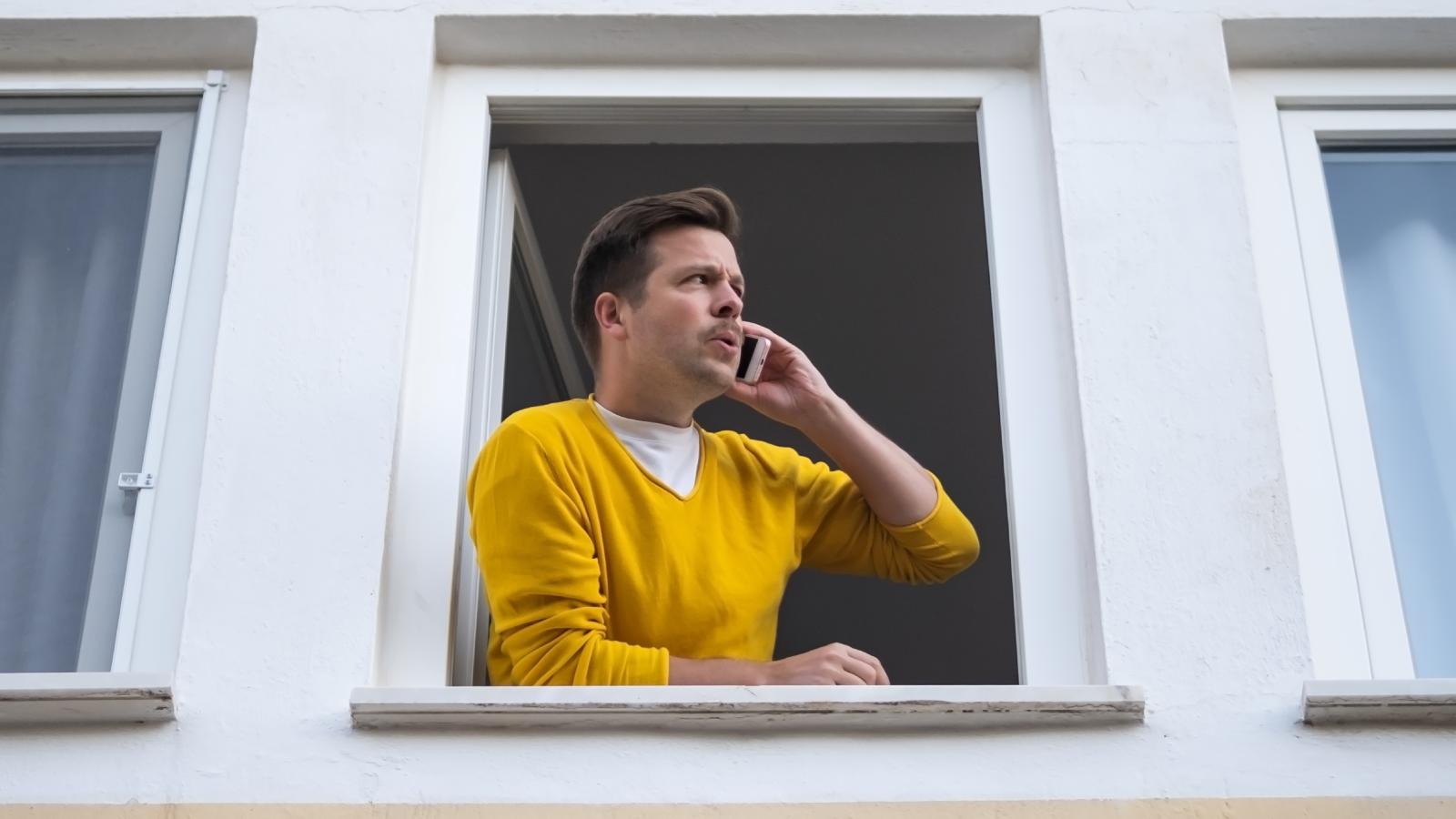man looking out window