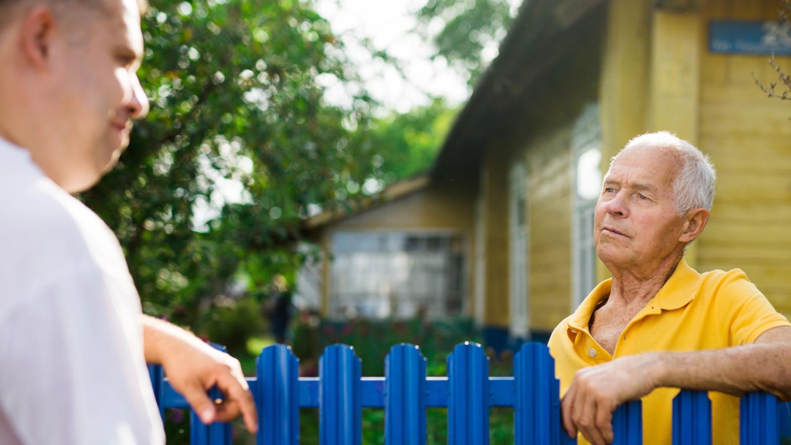 men talking near a fence