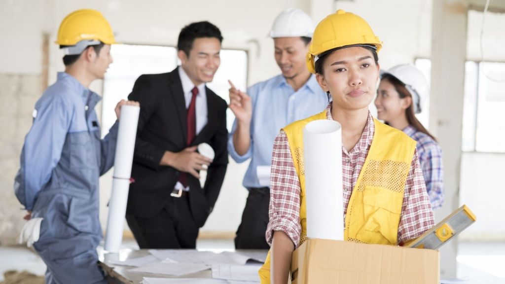 fired construction worker walking out with box