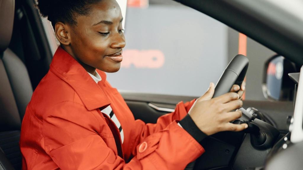 girl in orange holding the steering wheel
