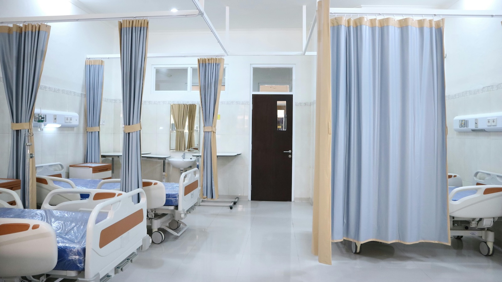 After Living at the Hospital for Two Months, One Woman Makes a Difficult Emotional Admission hospital room with beds, curtains, etc.