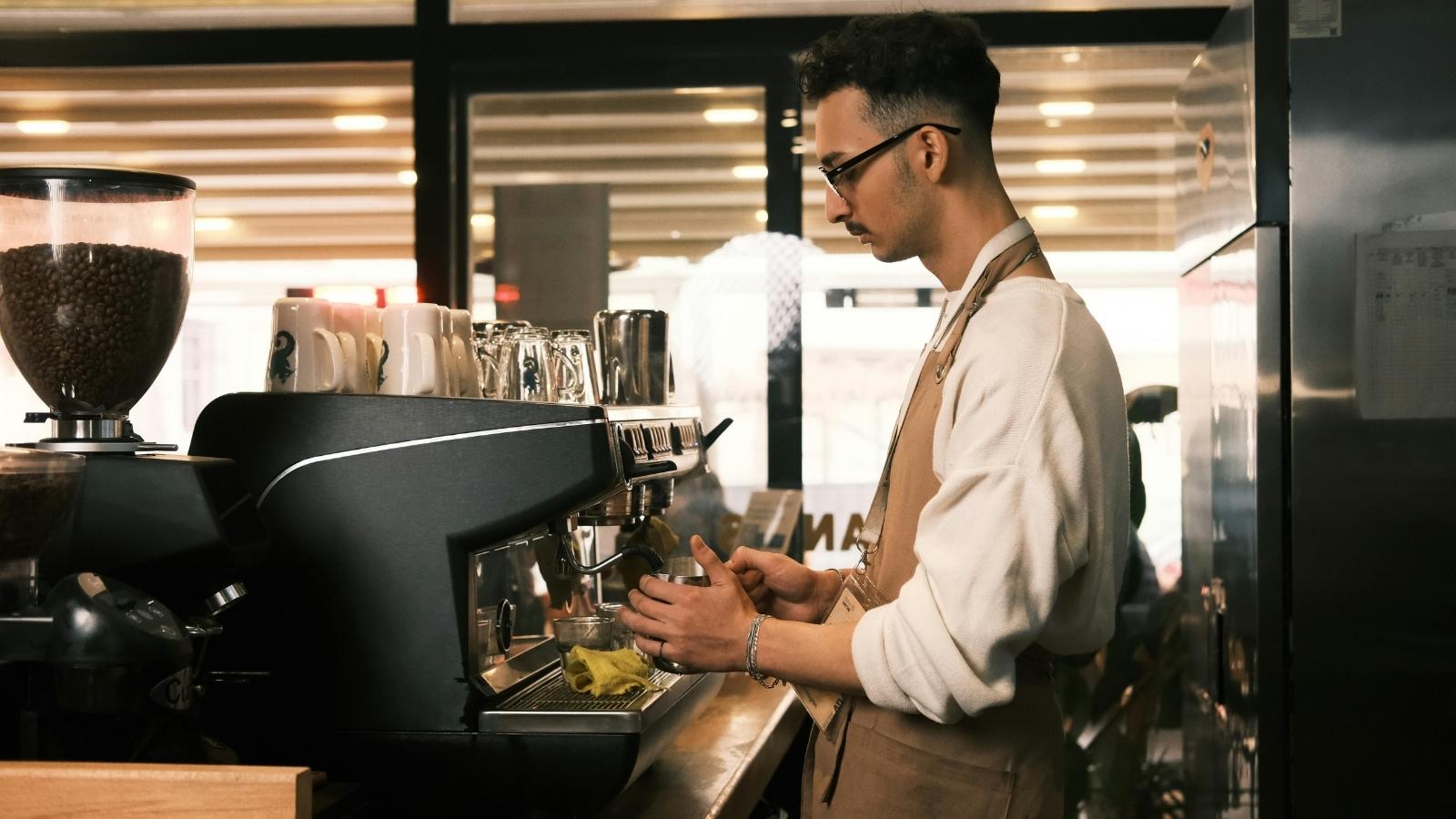Coffee Shop Employee Discovers Boss Is Keeping Credit Card Tips, Leaving Staff Afraid to Speak Up male barista brewing coffee