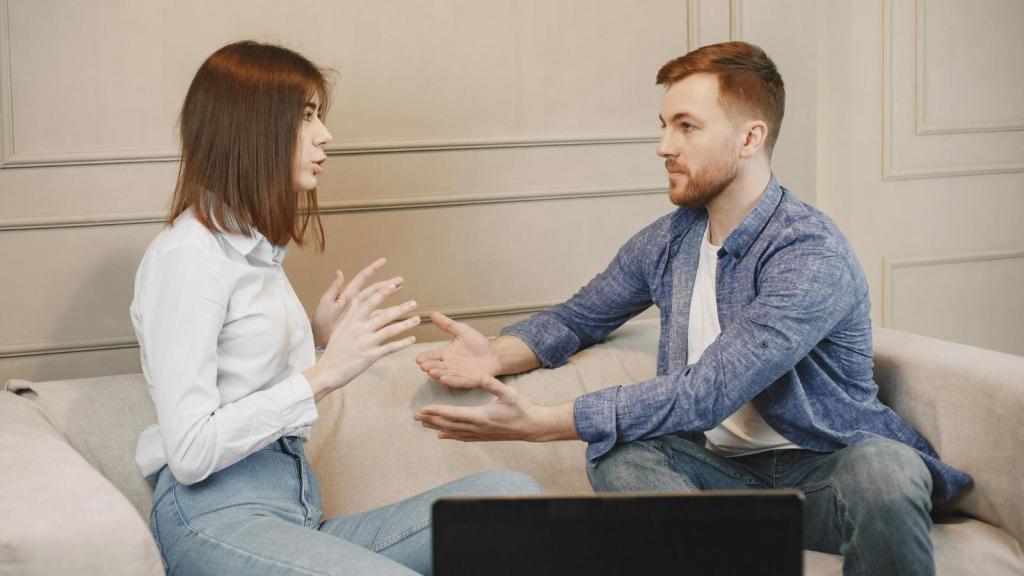 man and woman arguing on the couch