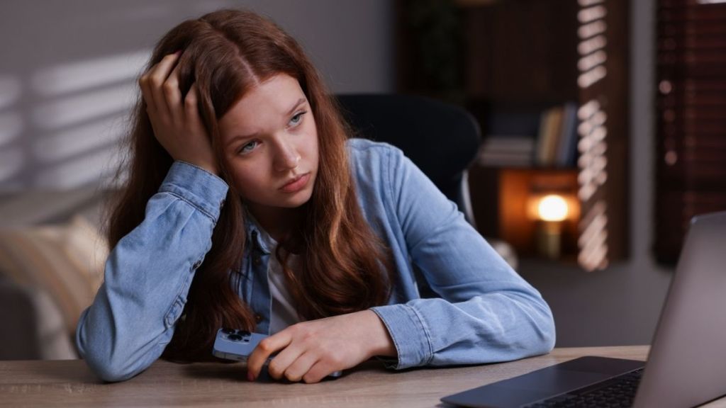 disappointed teen girl in front of laptop
