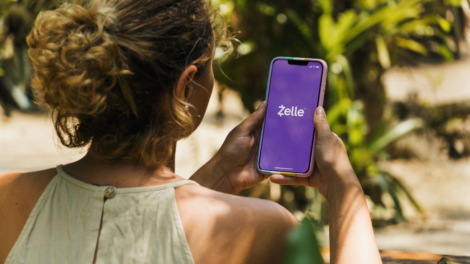 girl on the zelle app at the park
