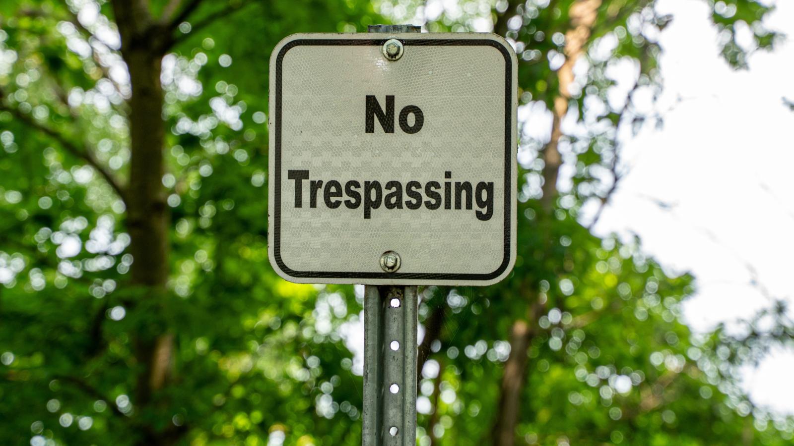 Homeowner Puts Up “No Trespassing” Sign After Neighbor Repeatedly Enters Her Yard no trespassing sign in the woods