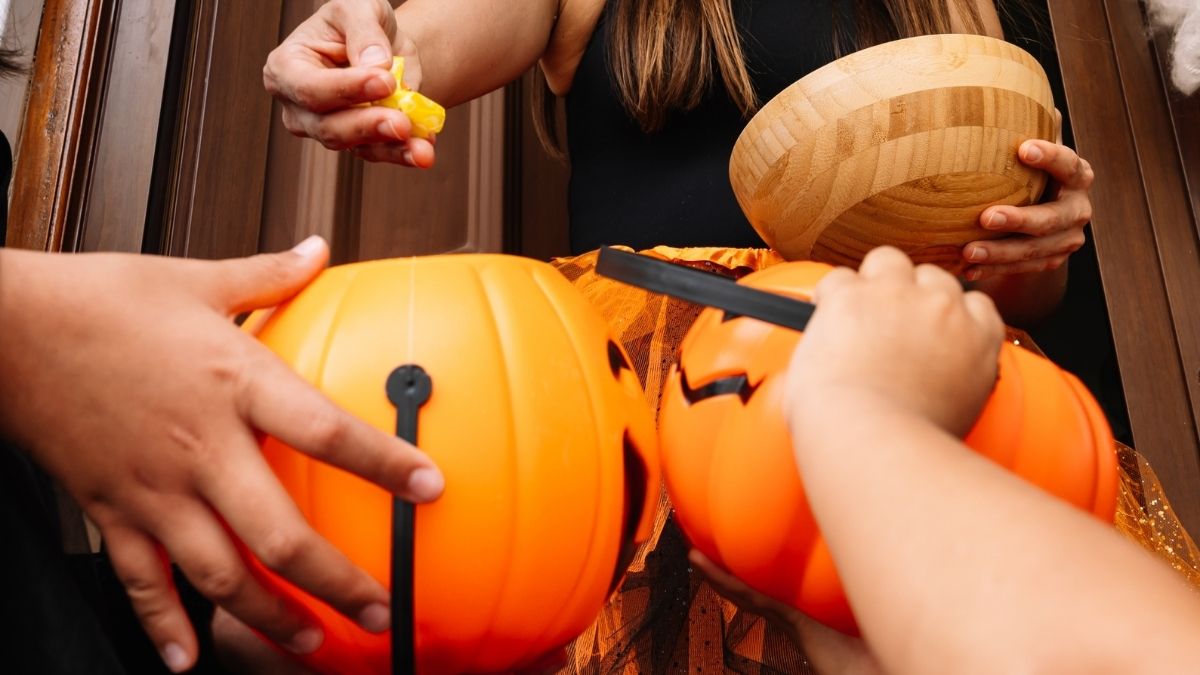 woman handing out halloween candy
