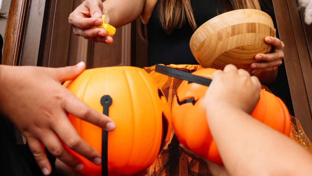 woman handing out halloween candy