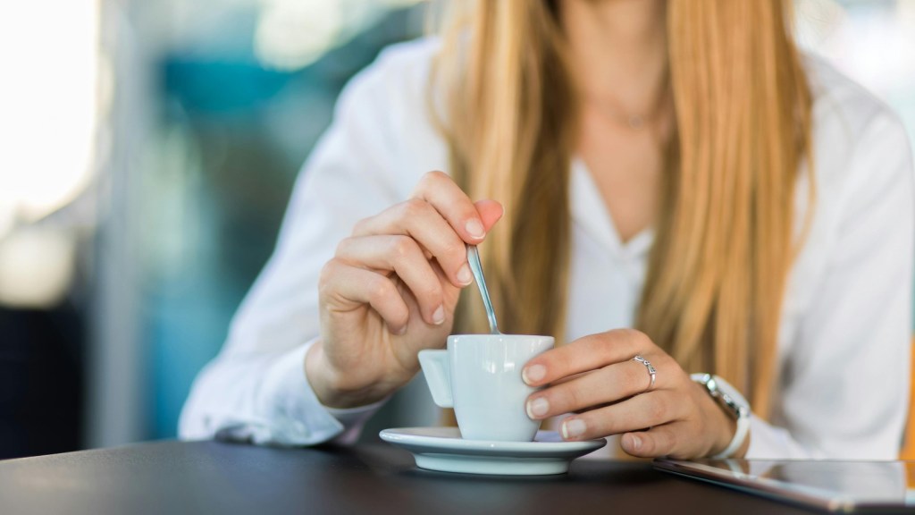 a woman stirring a cup of coffee