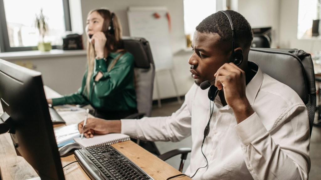 Man and woman answering phone calls at a desk