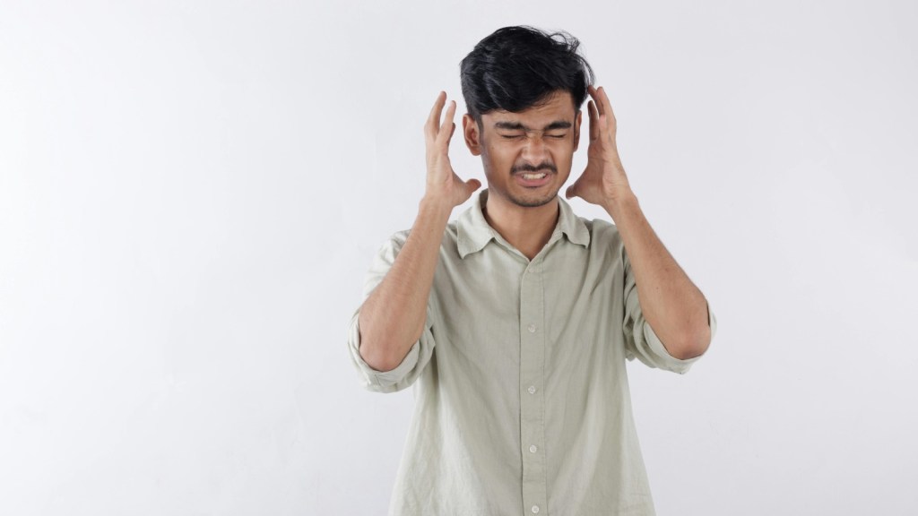 a frustrated man with his hands on either side of his head