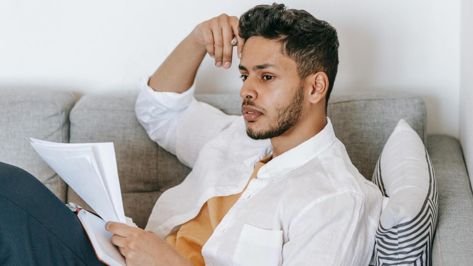 Young Man Wants to Move Out After Parents Keep Borrowing Money From Him man on a couch