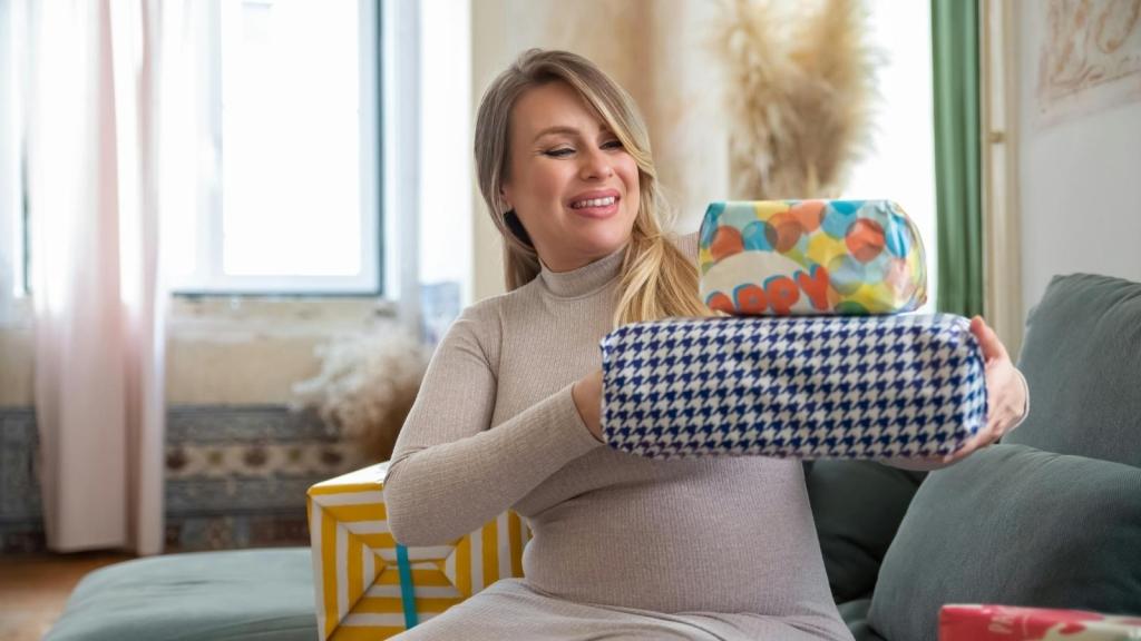 pregnant woman holding a stack of gifts