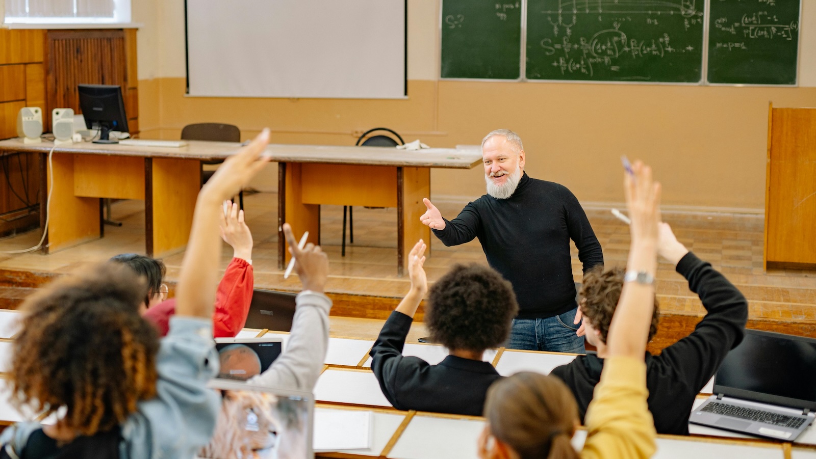 Look Up From Your Phones: The Viral Story of a Student Who Finally Called Out Their Peers professor at a college lecture with students raising hands
