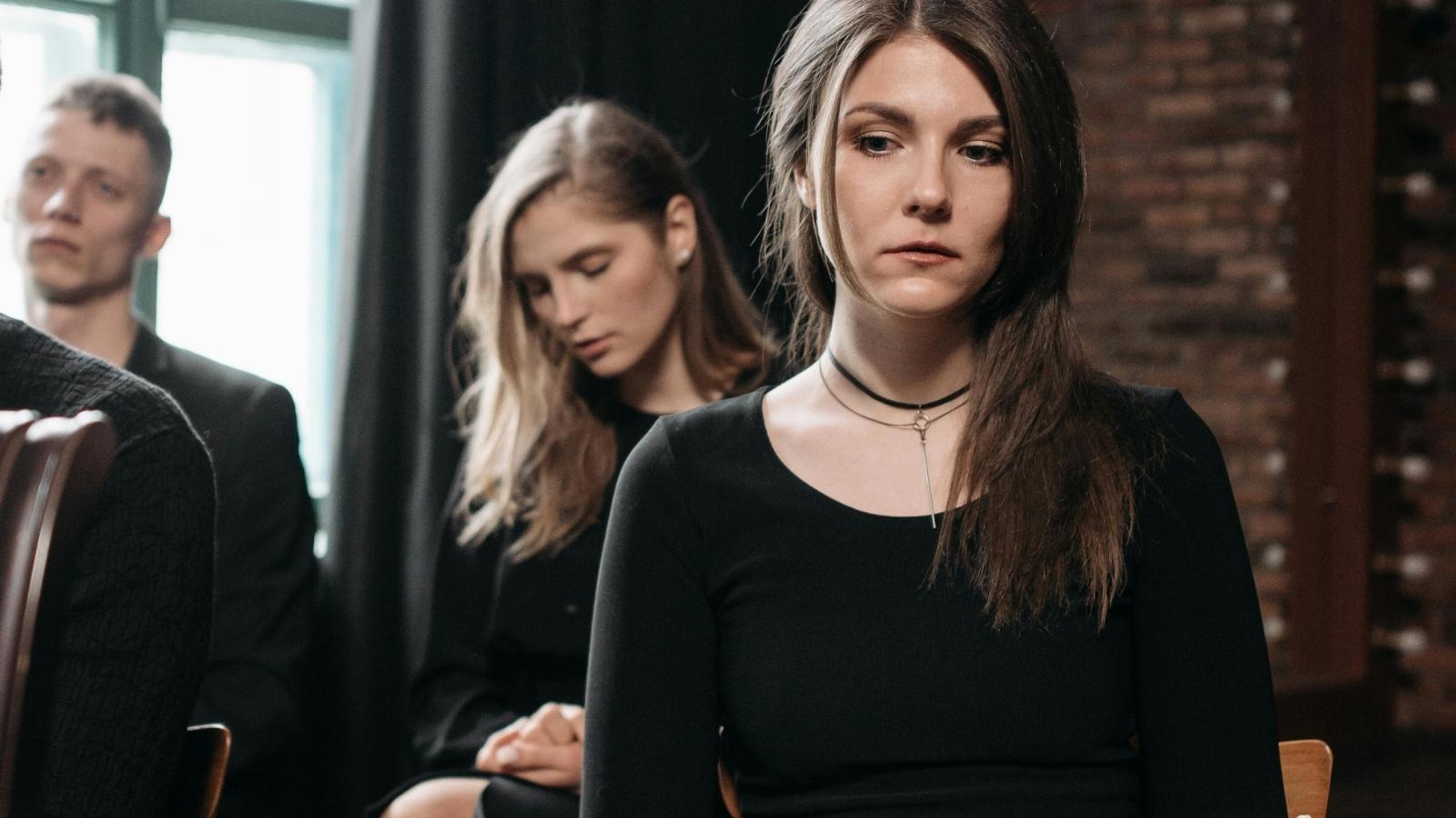 sad woman wearing black at a funeral