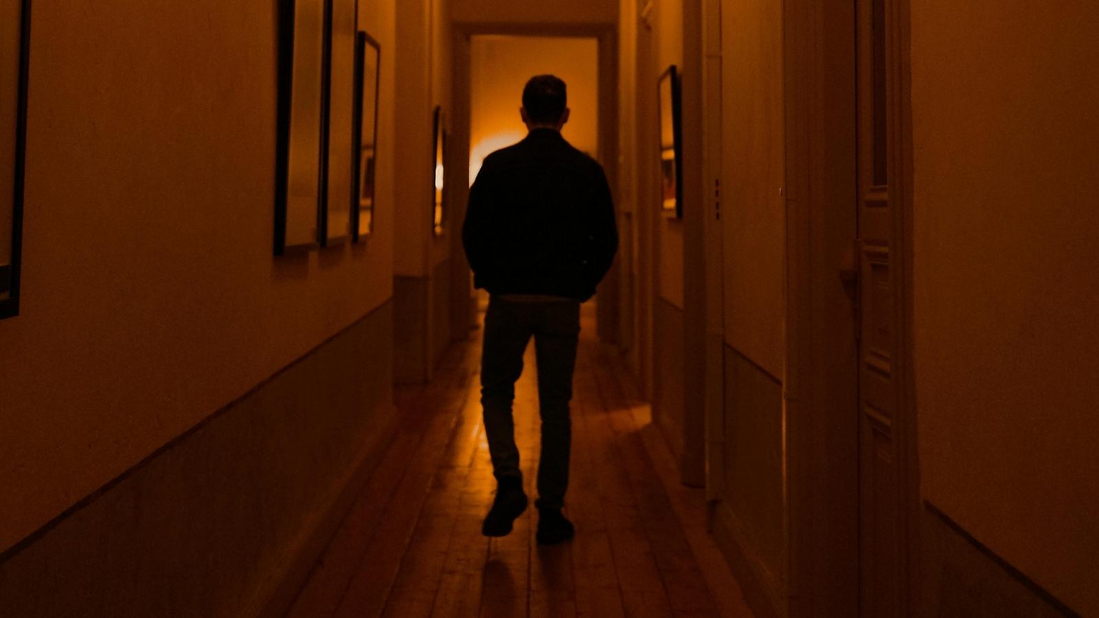 The Hallway Provocation: How a Bitter Neighbor’s Campaign to Agitate a Dog Was Defeated by Total Calm and a Hidden Lens shadow of a man walking in a hallway