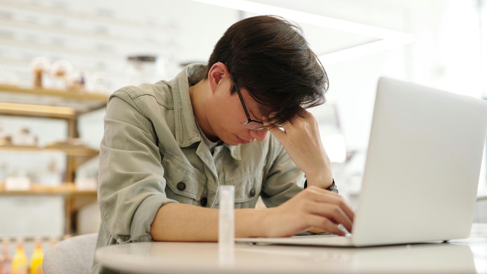 The Transnational Standoff: Why an Unannounced Birthday Trip Ended with a Family Stranded in a City Three Hours Away stressed man facepalming at his laptop