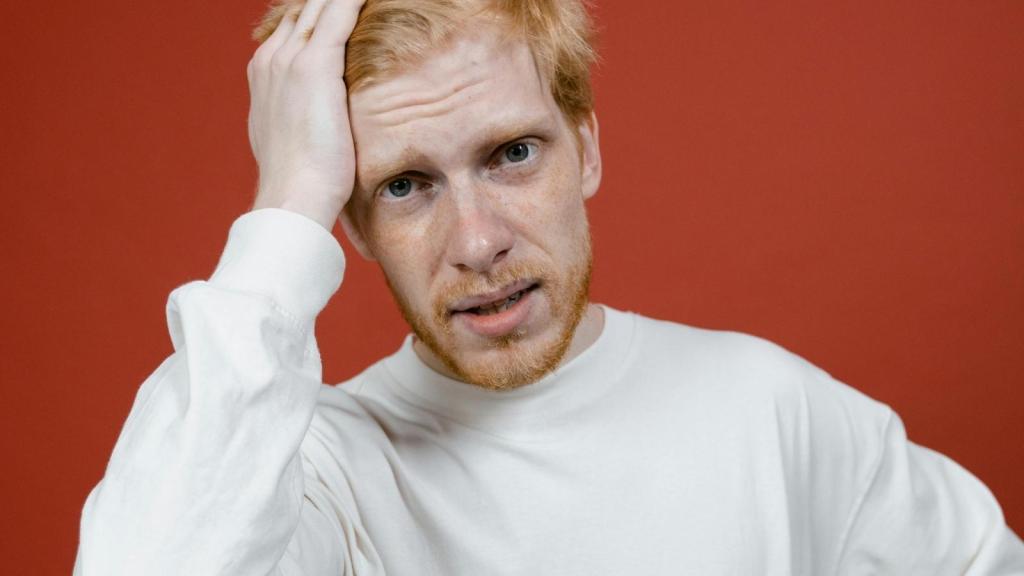 stressed man with his hand over head
