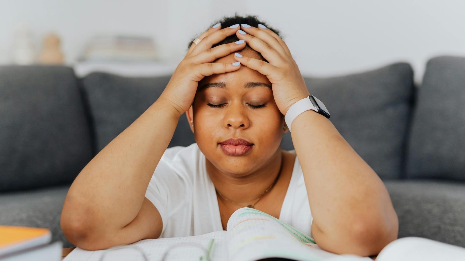 stressed young woman with her hands over her head