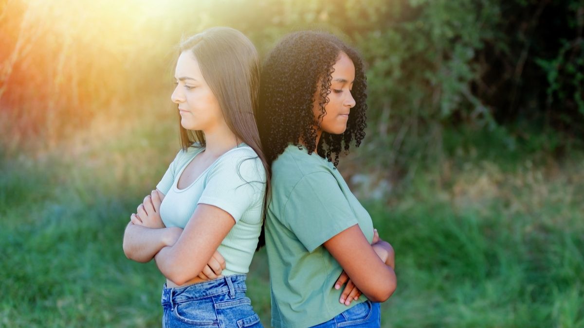 teen girls standing back to back