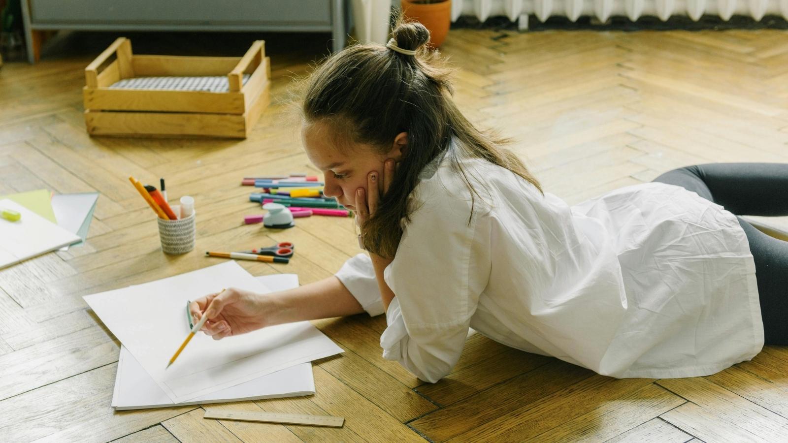 teenage girl drawing on the floor