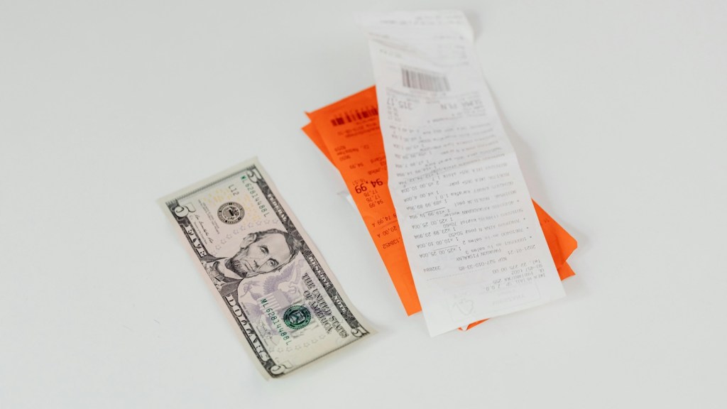 cash tip left next to a bill on a white table