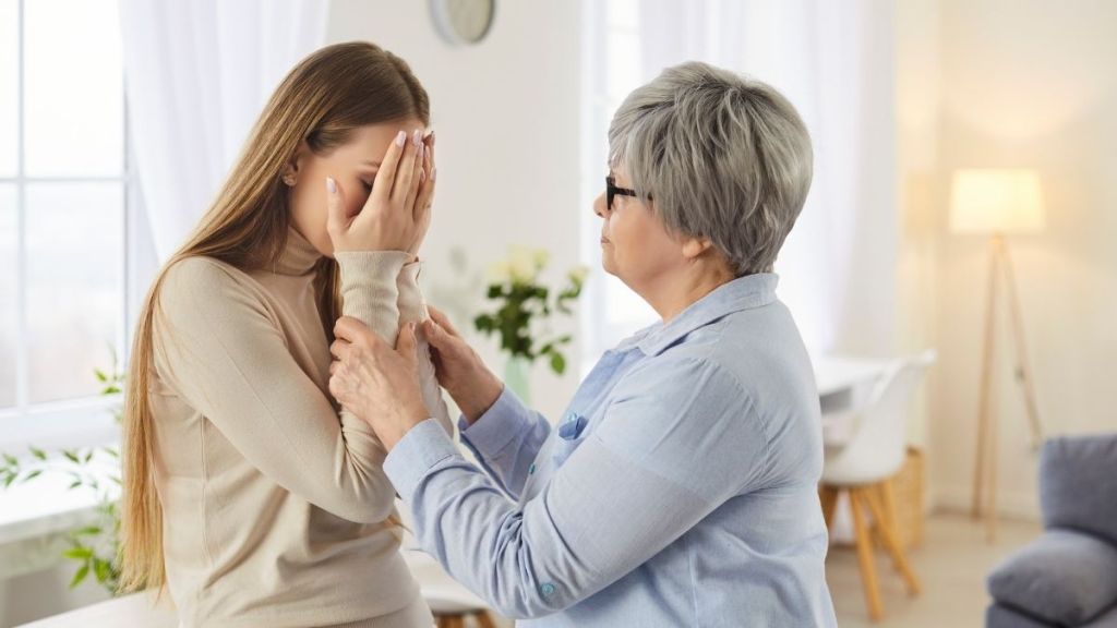 mother comforting adult daughter