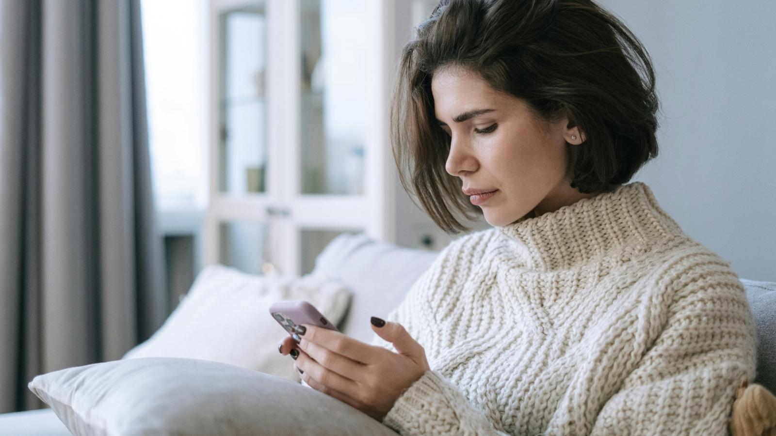 Upset woman looking at her phone