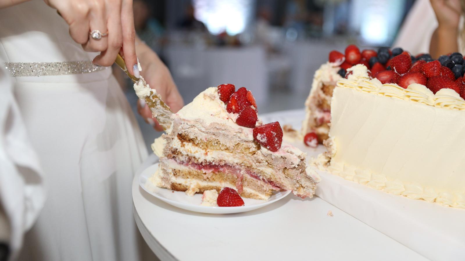 Bride and Groom Walk Over to Cut Their Custom Wedding Cake—Only to Find Greedy Guests Already Devoured Most of It person cutting wedding cake