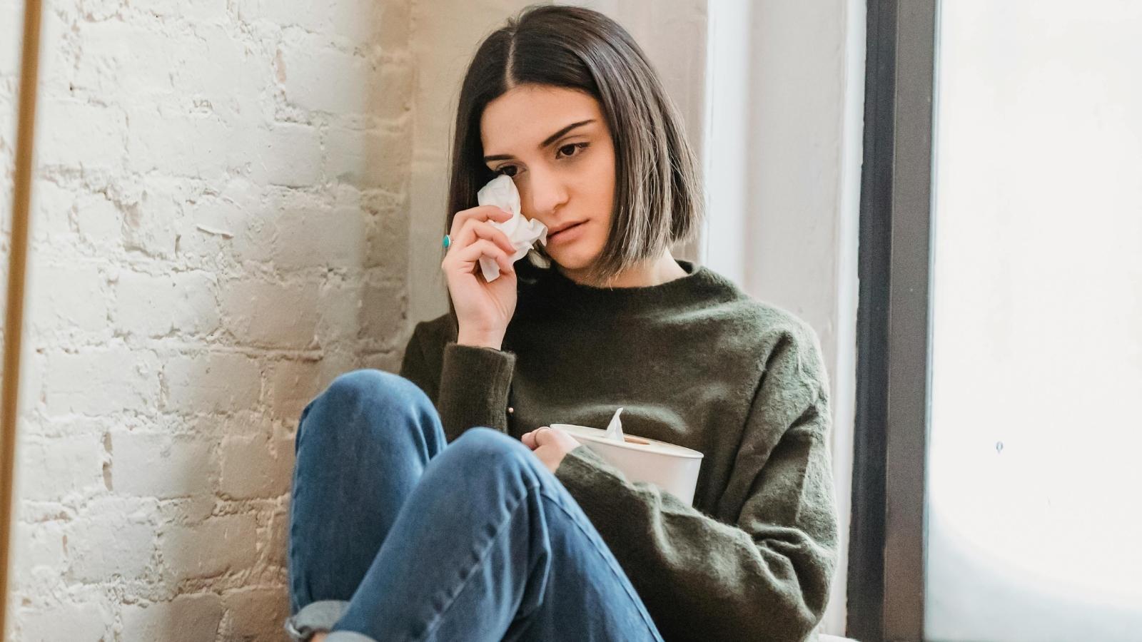 Woman Cuts Off Married Friend After Discovering He Hid Their Friendship From His Wife woman crying with a box of tissues