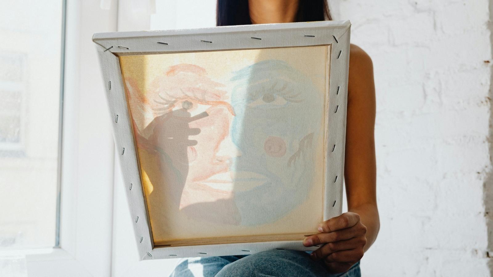 woman holding up an abstract painting