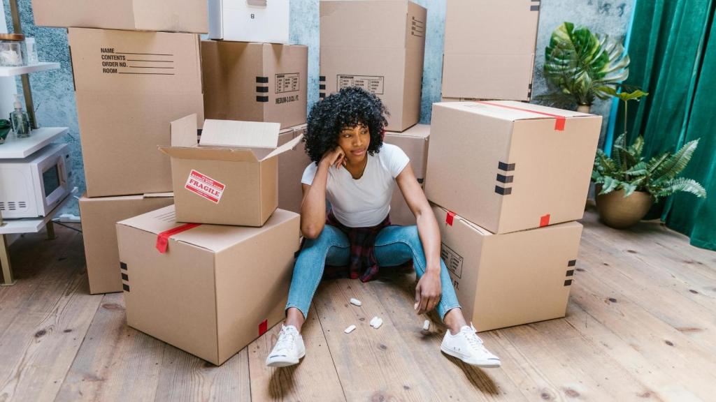 woman sitting in front of a pile of moving boxes