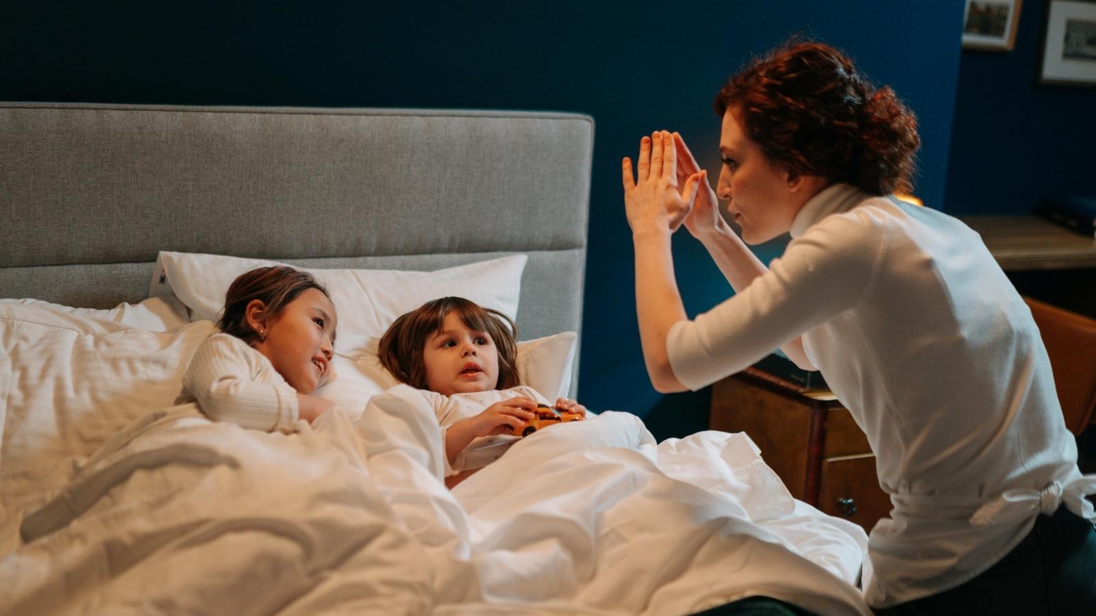 woman telling two kids a bedtime story