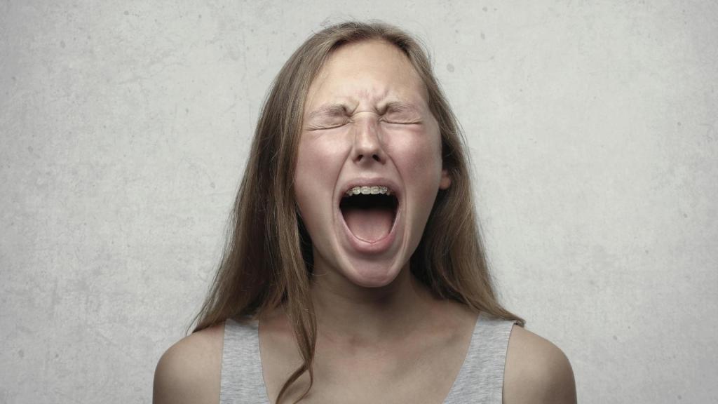 woman yelling against grey background