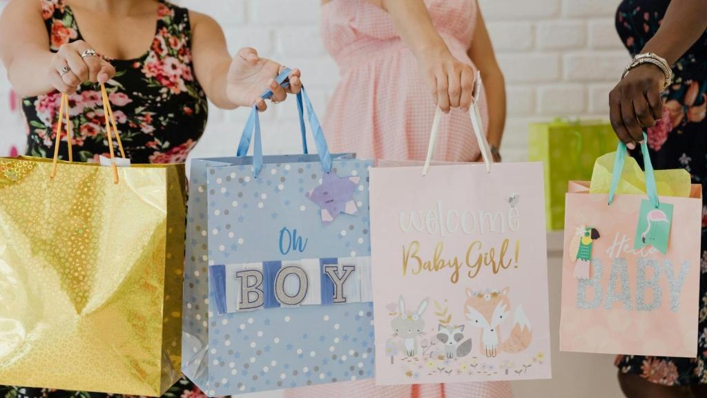 women holding up gifts for a baby shower
