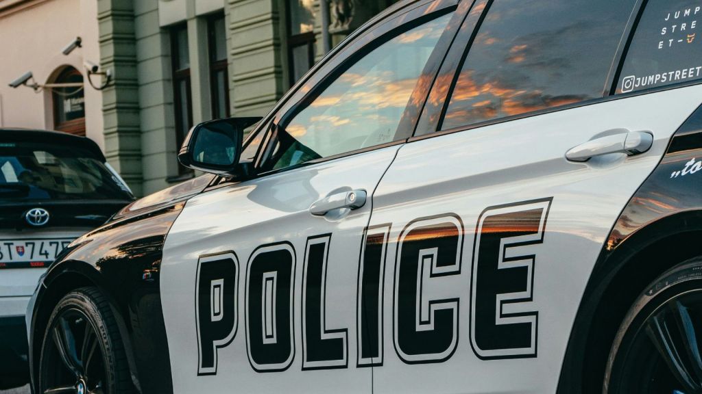 A police car parked in front of an apartment building