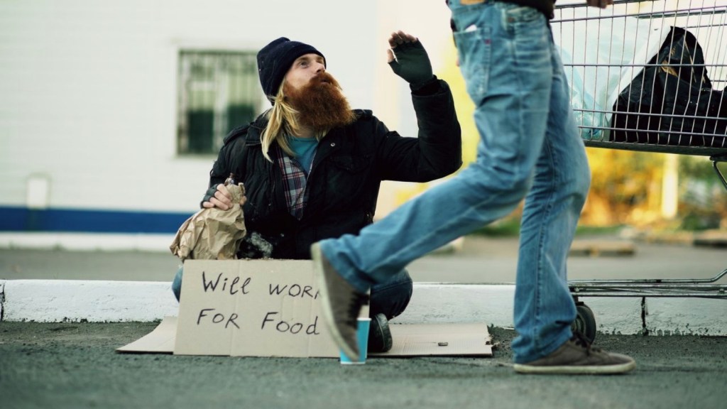 Homeless man holding a sign