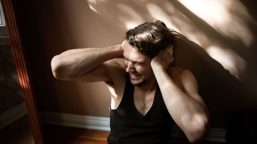 A guy covering his ears