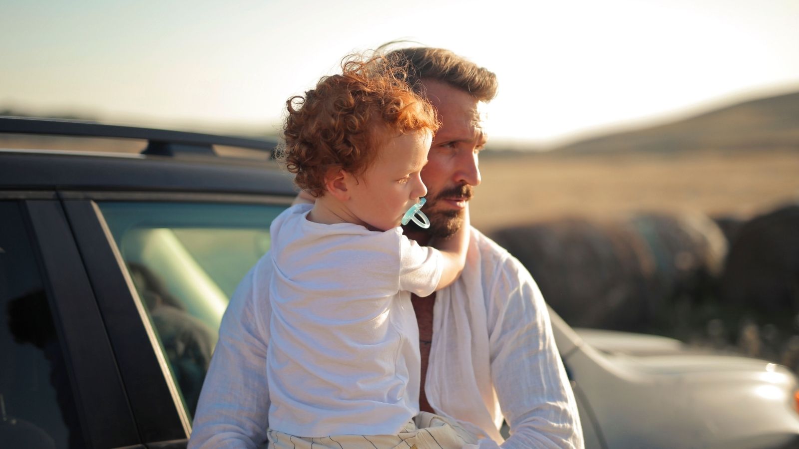 She Tolerated His Affair Partner. Now, Her Ex Is Furious Over Who She’s Dating. A man holding a boy by a car