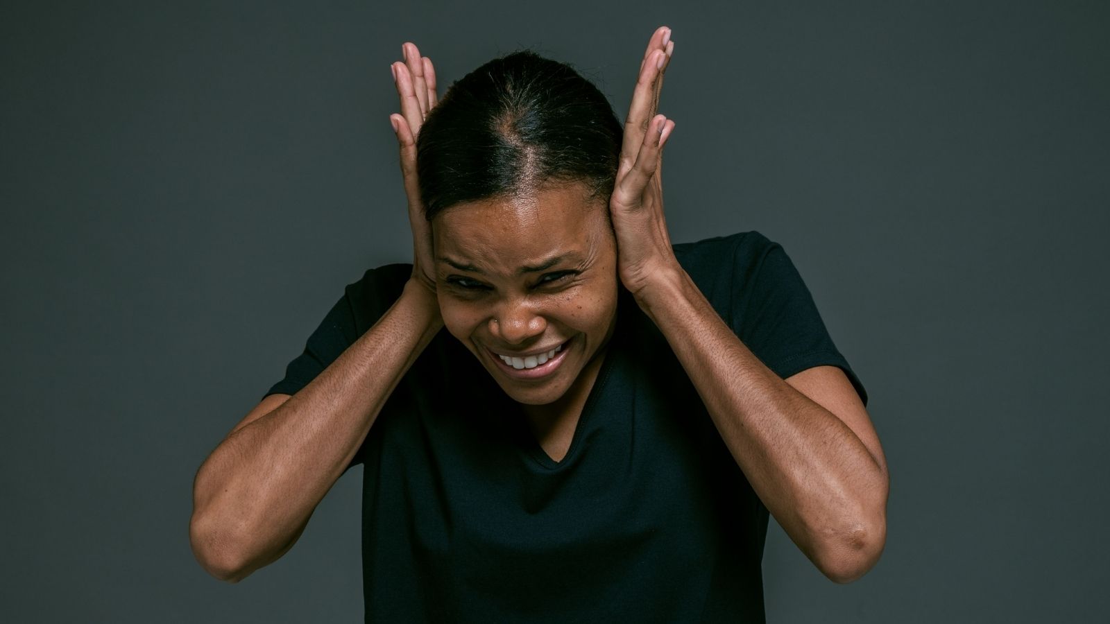 A woman covering her ears