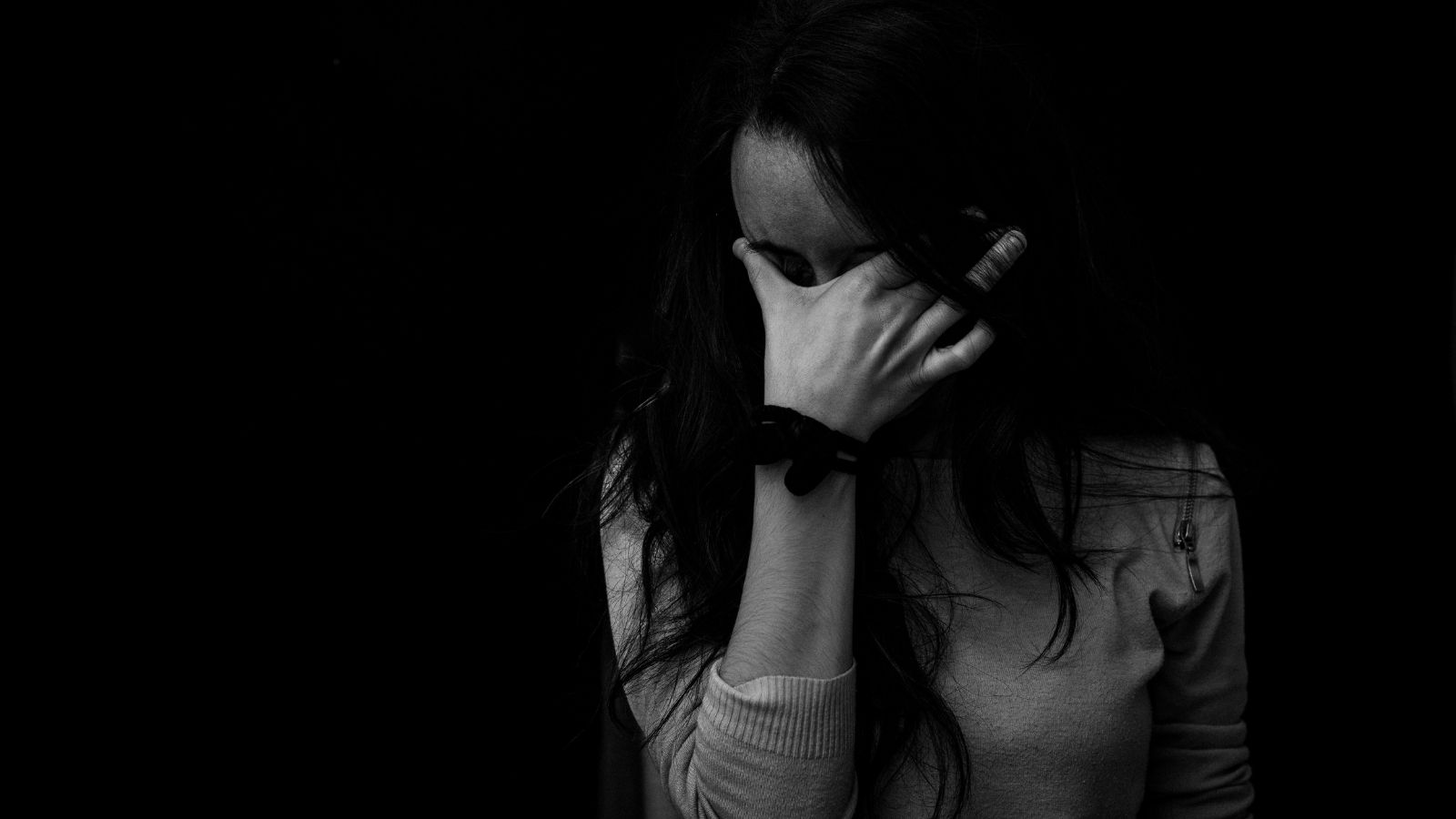A woman covering her eyes