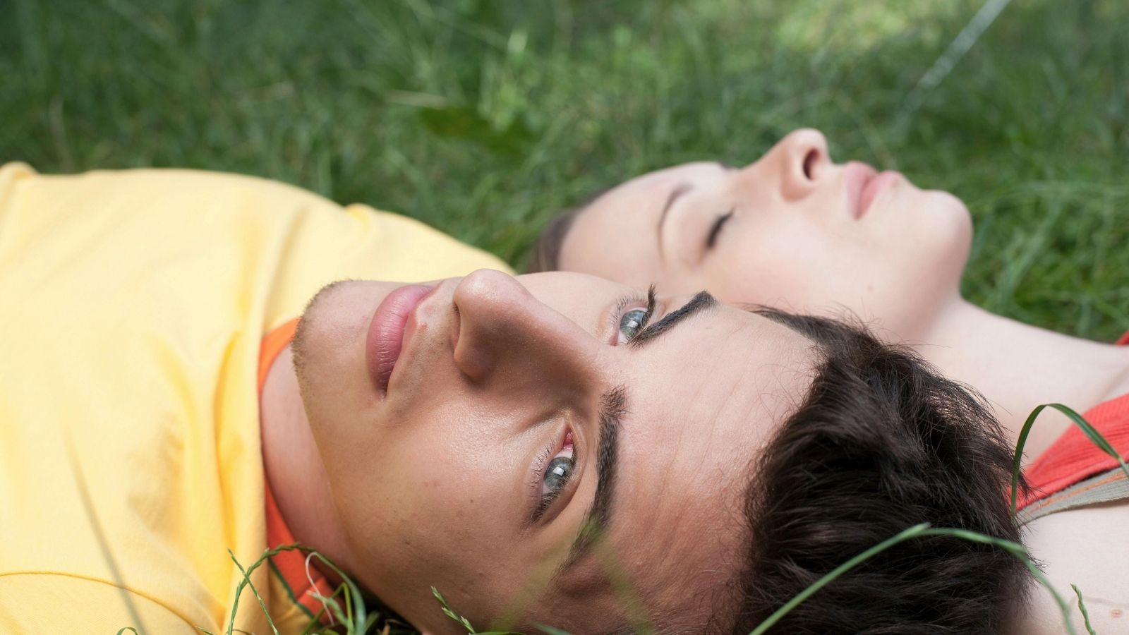 A man and woman lying on the grass