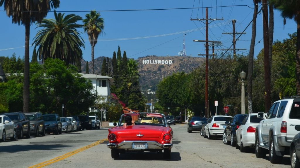A car driving toward the Hollywood hills sign