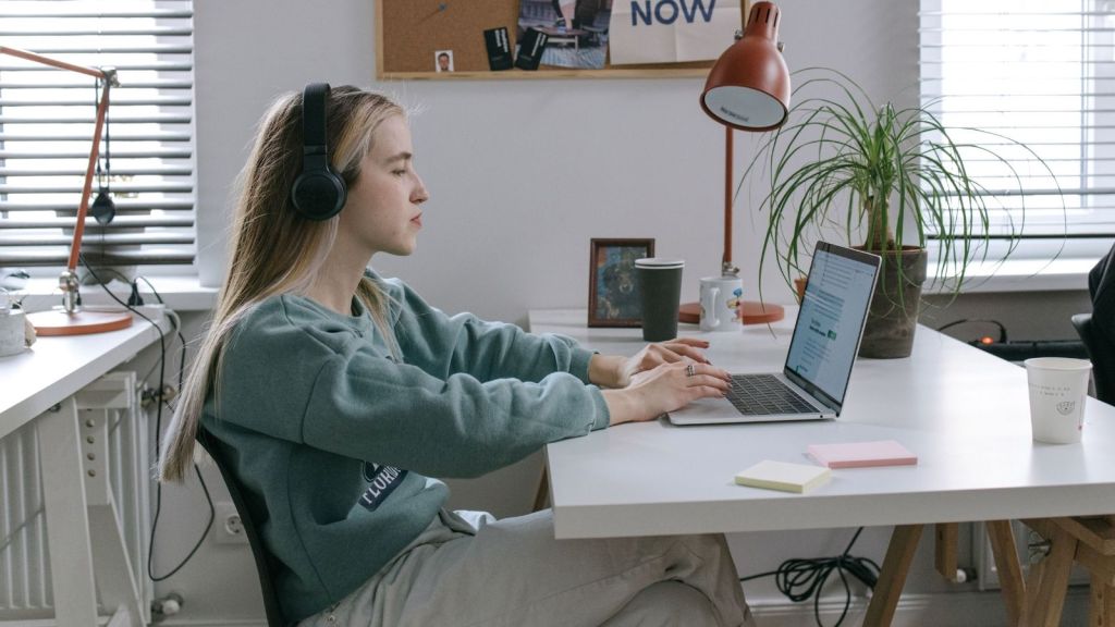 A young woman working at a laptop in an office