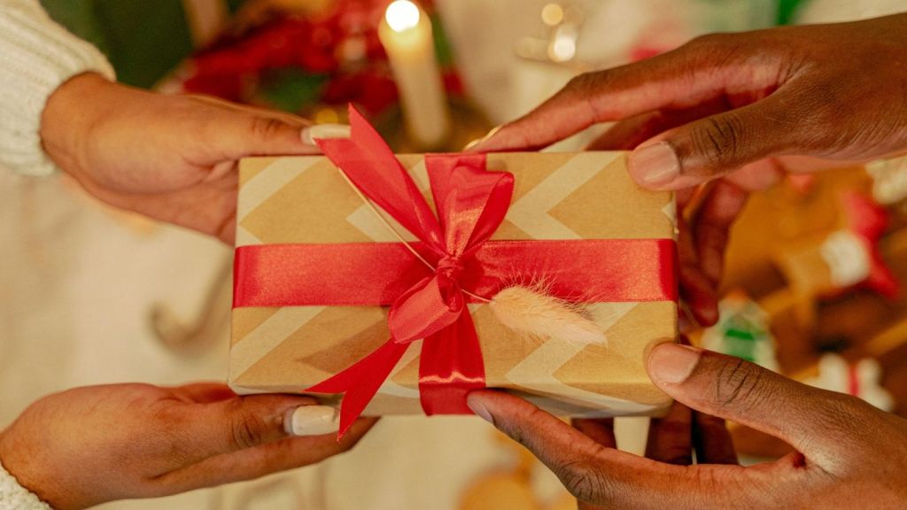A man and a woman's hands exchanging a gift